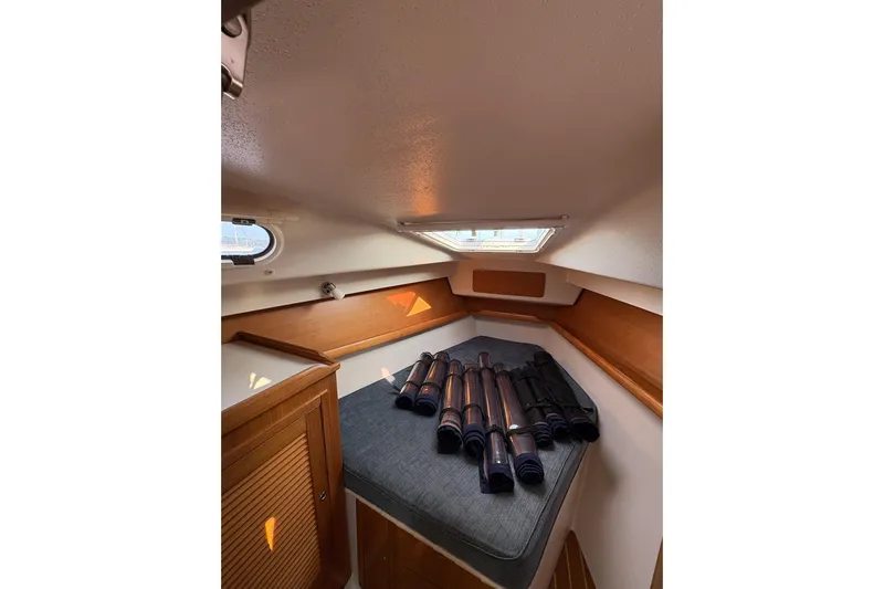 Rendez-vous Yacht Photos Pics Cozy cabin interior of 2003 Catalina 387 sailboat with rolled sails on bed.