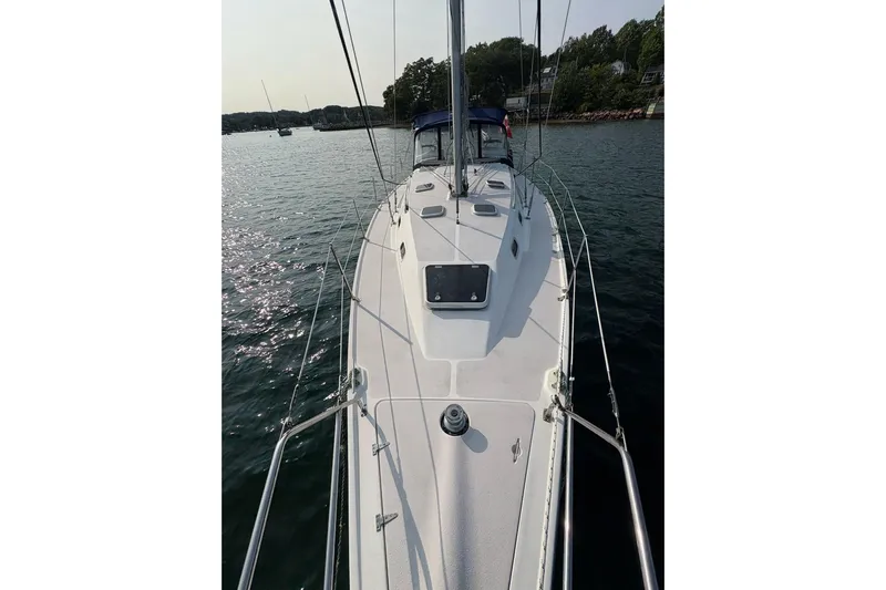 Rendez-vous Yacht Photos Pics Sailboat Catalina 387, 2003 model, on calm water with scenic shoreline.