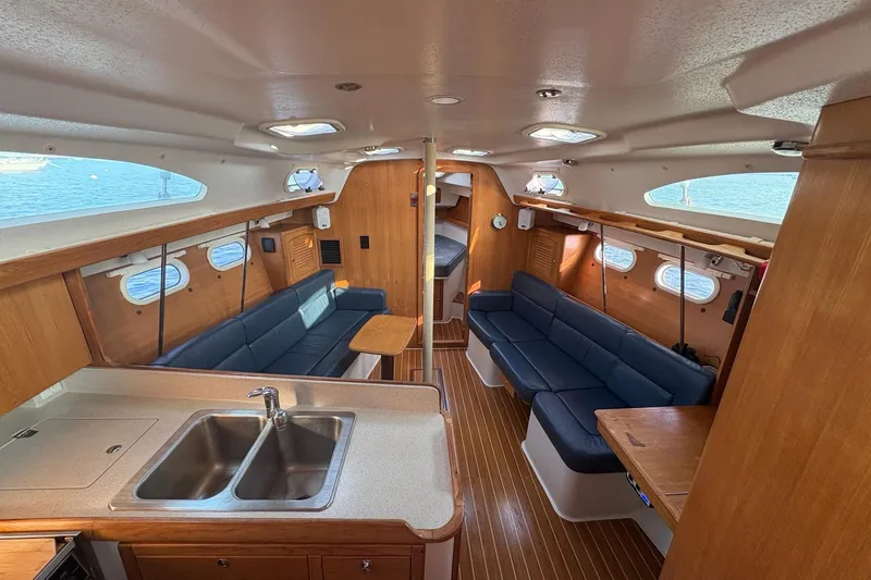 Rendez-vous Yacht Photos Pics Interior of 2003 Catalina 387 sailboat with spacious seating and modern kitchen area.
