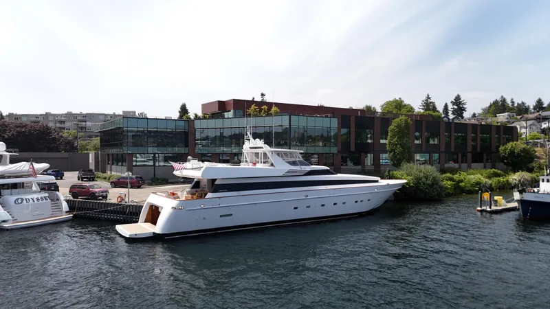 Arrivederci IV Yacht Photos Pics Luxury yacht Cantieri di Pisa AKHIR 1998 docked by modern waterfront building.