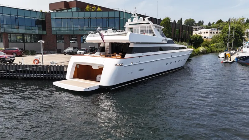 Arrivederci IV Yacht Photos Pics Luxury 1998 Cantieri di Pisa AKHIR yacht docked by modern waterfront buildings.