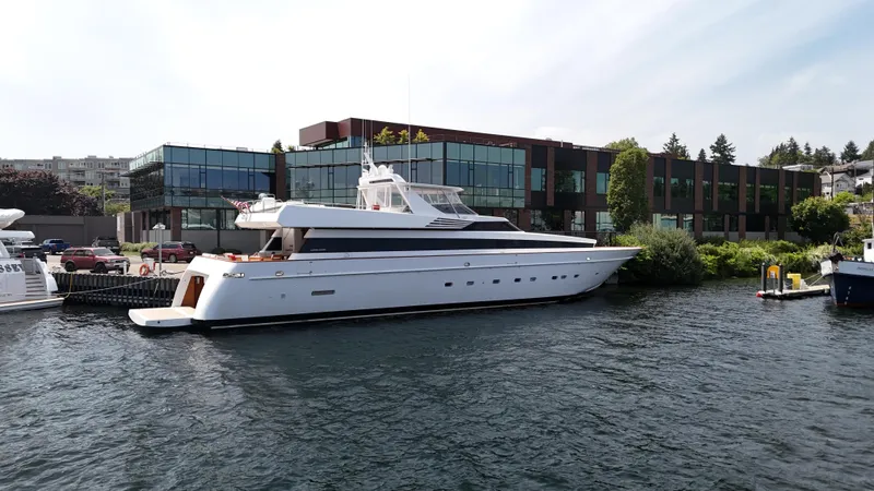 Arrivederci IV Yacht Photos Pics Luxury 1998 Cantieri di Pisa AKHIR yacht docked by modern waterfront building.