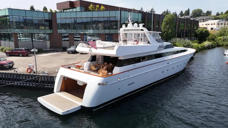 Arrivederci IV Yacht Photos Pics Cantieri di Pisa AKHIR 1998 yacht docked near modern building, featuring sleek design and spacious deck.