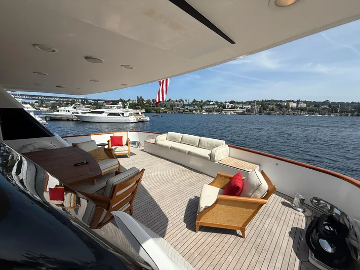 Arrivederci IV Yacht Photos Pics Luxurious 1998 Cantieri di Pisa AKHIR yacht deck with elegant seating and scenic waterfront view.