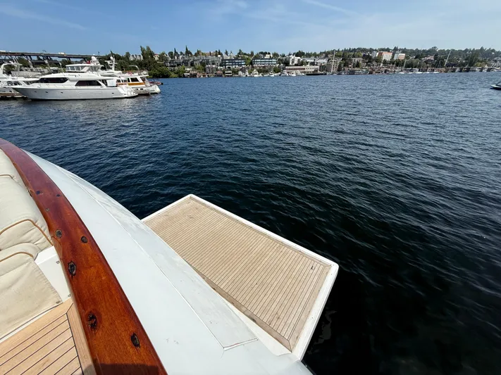 Arrivederci IV Yacht Photos Pics Luxury yacht Cantieri di Pisa AKHIR 1998 on serene water with scenic shoreline view.