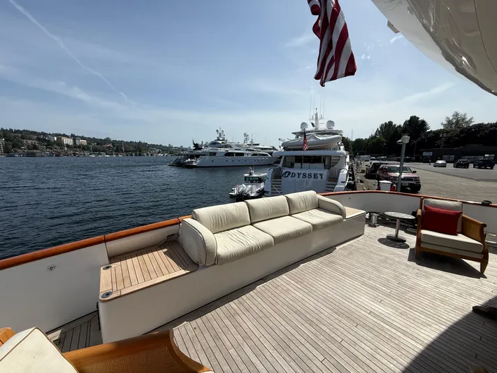 Arrivederci IV Yacht Photos Pics Luxury yacht deck with seating, Cantieri di Pisa AKHIR 1998, docked by the waterfront.