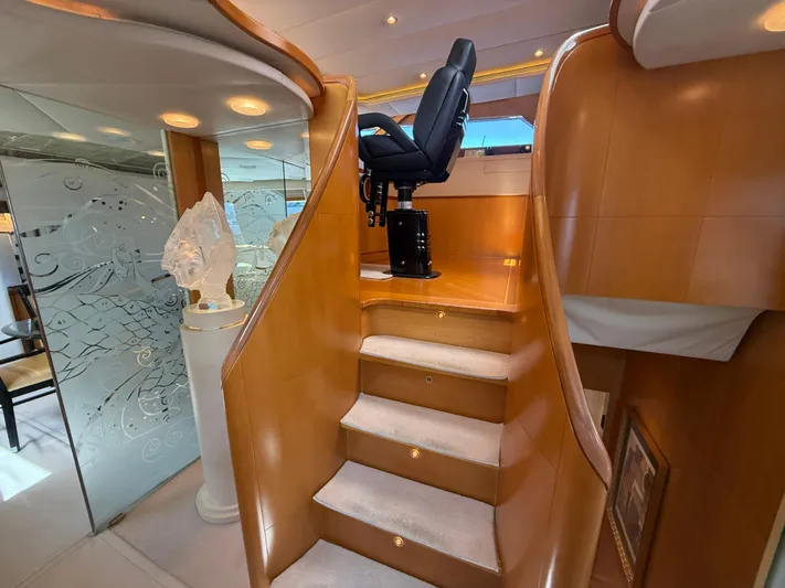 Arrivederci IV Yacht Photos Pics Luxurious interior of 1998 Cantieri di Pisa AKHIR yacht with elegant wooden staircase and captain's chair.