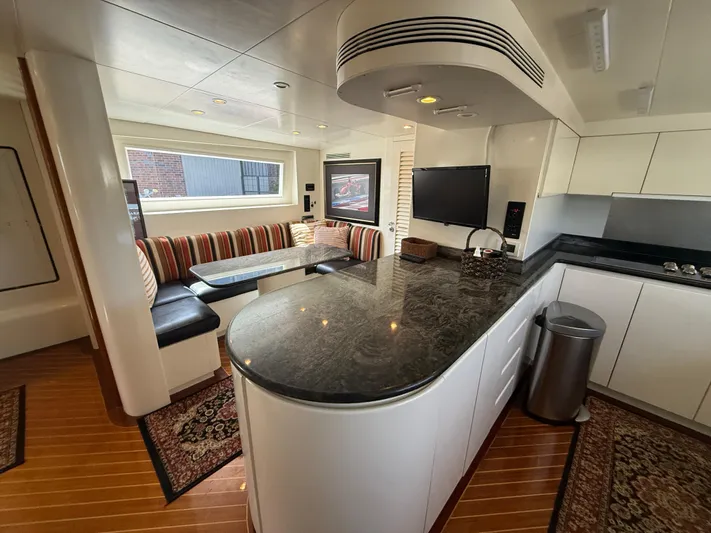 Arrivederci IV Yacht Photos Pics Luxurious 1998 Cantieri di Pisa AKHIR yacht interior with modern kitchen and cozy seating area.