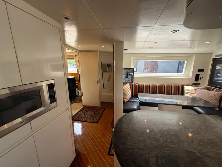 Arrivederci IV Yacht Photos Pics Luxurious 1998 Cantieri di Pisa AKHIR yacht interior with modern kitchen and cozy seating area.