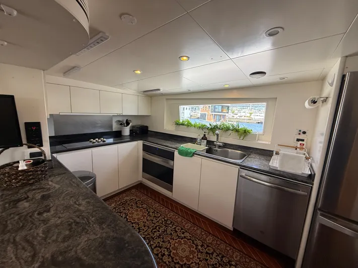 Arrivederci IV Yacht Photos Pics Modern kitchen interior on 1998 Cantieri di Pisa AKHIR yacht, featuring sleek countertops and stainless steel appliances.
