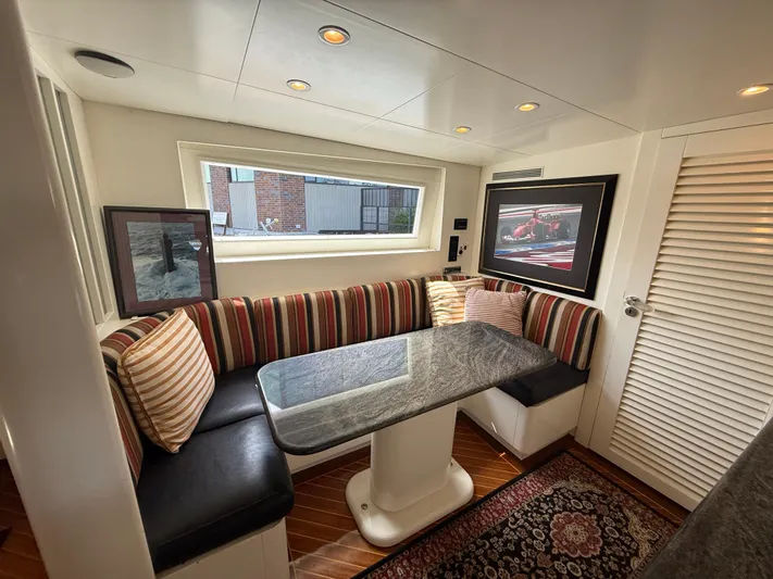 Arrivederci IV Yacht Photos Pics Cozy dining area on 1998 Cantieri di Pisa AKHIR yacht with striped seating and elegant decor.