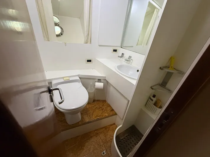 Arrivederci IV Yacht Photos Pics Compact yacht bathroom with toilet, sink, and storage shelves in 1998 Cantieri di Pisa AKHIR.