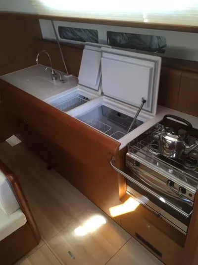  Yacht Photos Pics 2019 Jeanneau Sun Odyssey 479 yacht kitchen with stove, sink, and open fridge.
