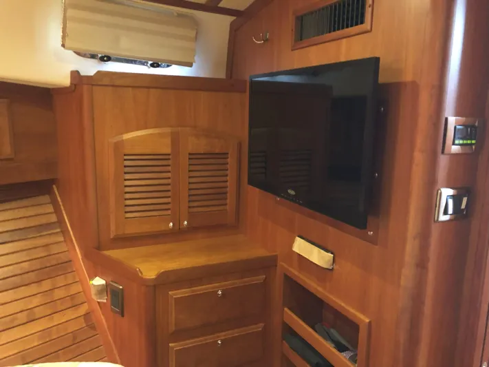 Southern Charm Yacht Photos Pics Interior of 2010 Sabre 40 Sedan with wooden cabinetry and mounted TV.