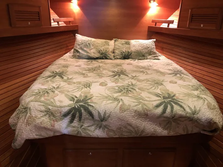 Southern Charm Yacht Photos Pics Cozy bedroom in 2010 Sabre 40 Sedan with tropical-themed bedding and warm lighting.