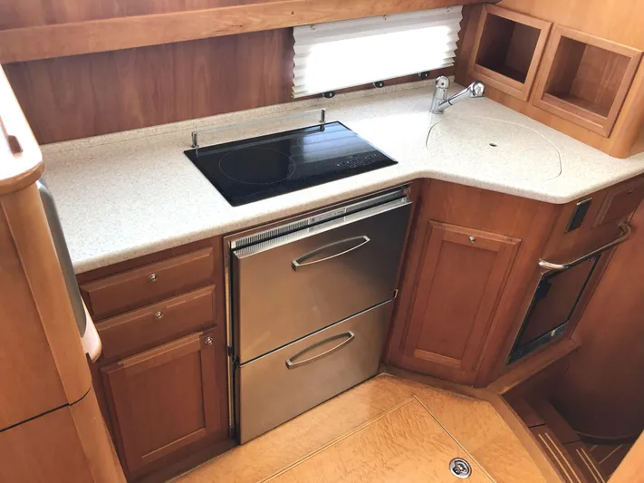 Southern Charm Yacht Photos Pics 2010 Sabre 40 Sedan kitchen with stove, sink, and wooden cabinetry.