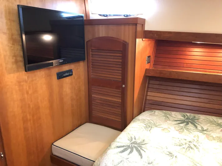 Southern Charm Yacht Photos Pics Interior of 2010 Sabre 40 Sedan with TV, wooden paneling, and floral bedding.