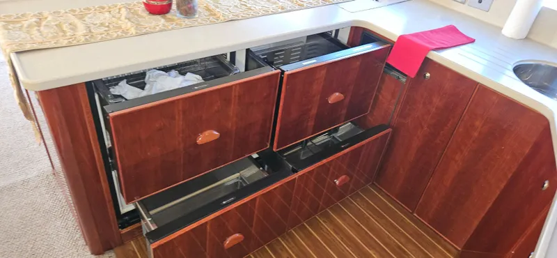 Christina Yacht Photos Pics 2004 Riviera 58 Enclosed Flybridge kitchen with open wooden drawers and countertop.