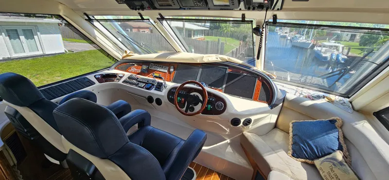 Christina Yacht Photos Pics Interior of 2004 Riviera 58 Enclosed Flybridge with helm, seating, and waterfront view.