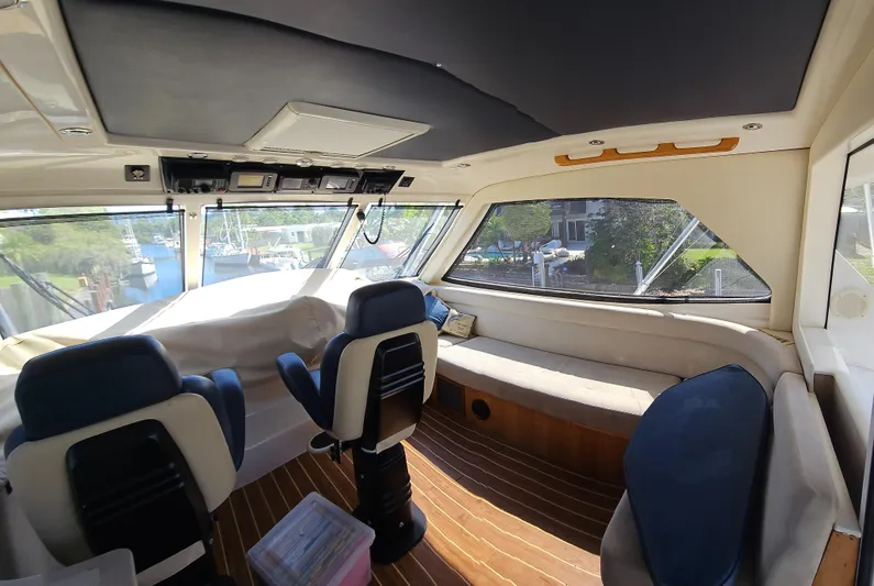 Christina Yacht Photos Pics 2004 Riviera 58 Enclosed Flybridge interior with seating and helm, featuring panoramic windows.