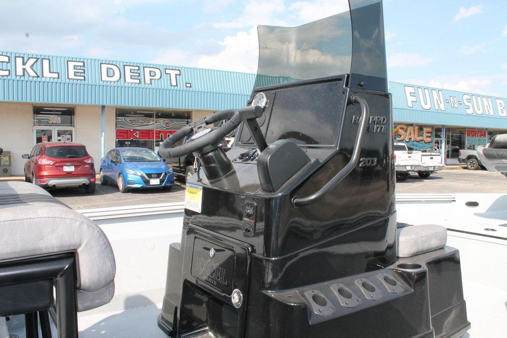 2026 Excel Bay Pro Elite 203 boat console at dealership, with storefront in background.