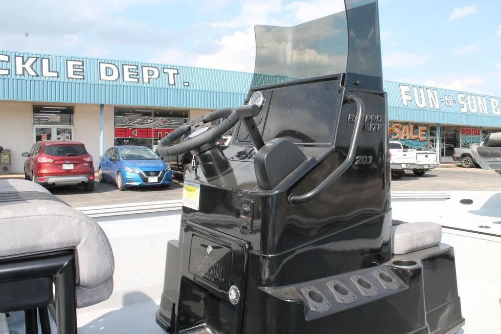2026 Excel Bay Pro Elite 203 boat console at dealership, with storefront in background.