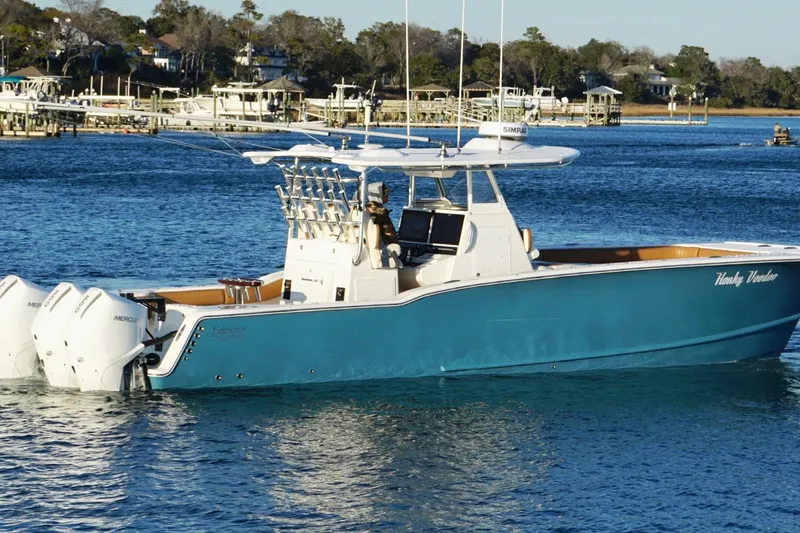  Yacht Photos Pics 2022 Tideline 365 Offshore boat on calm water, featuring triple Mercury engines.