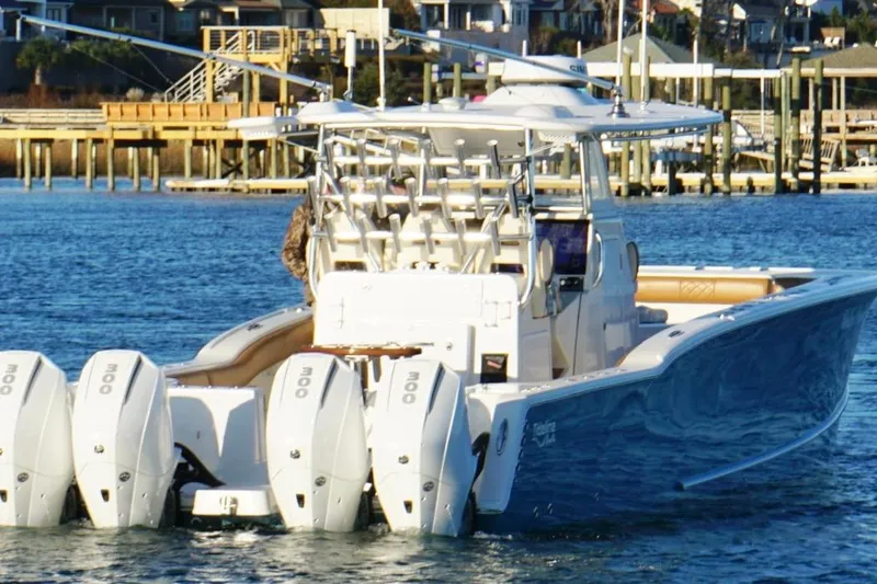  Yacht Photos Pics 2022 Tideline 365 Offshore boat with multiple engines on a calm waterway.