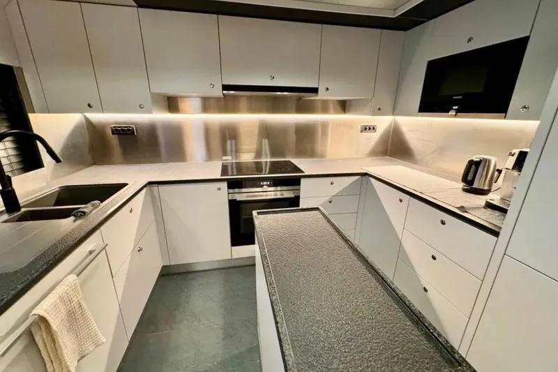  Yacht Photos Pics Modern kitchen in 2024 Explorer ICE, featuring sleek cabinetry and stainless steel appliances.