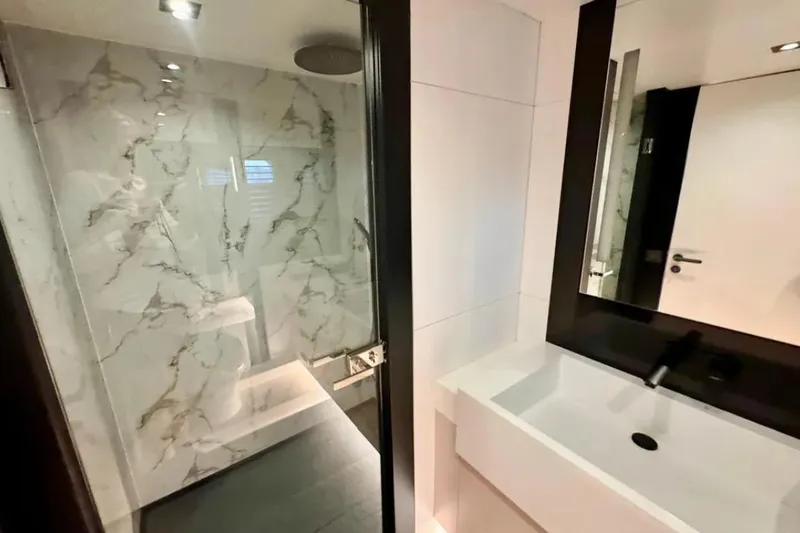  Yacht Photos Pics Modern bathroom with marble shower and sleek white sink, 2024 Explorer ICE model.