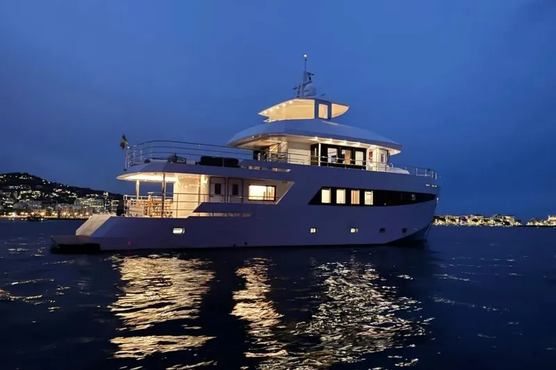  Yacht Photos Pics 2024 Explorer ICE yacht illuminated at night on calm waters.