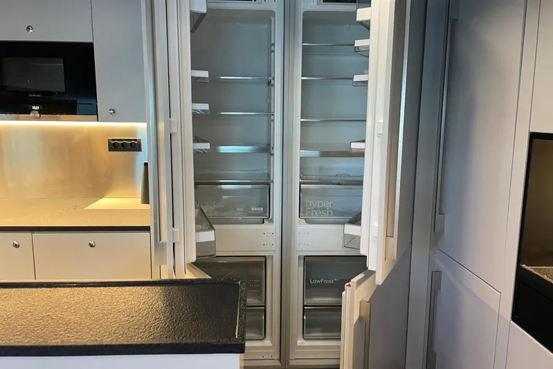  Yacht Photos Pics Modern kitchen with open 2024 Explorer ICE refrigerator, showcasing spacious interior and sleek design.