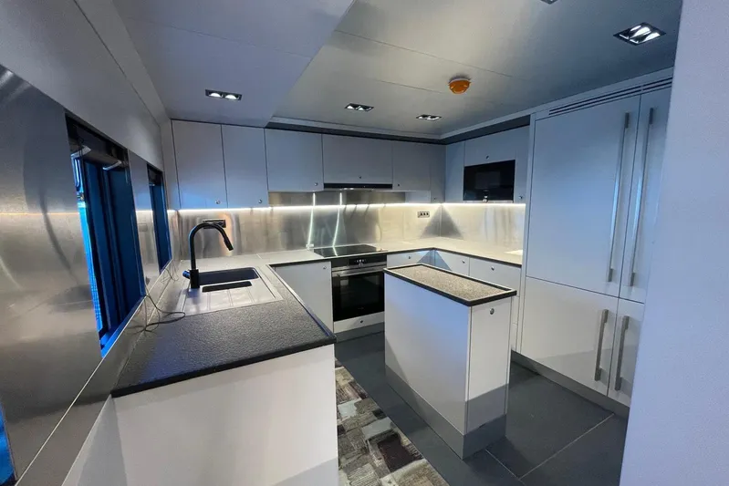  Yacht Photos Pics Modern kitchen interior in 2024 Explorer ICE, featuring sleek cabinetry and stainless steel accents.