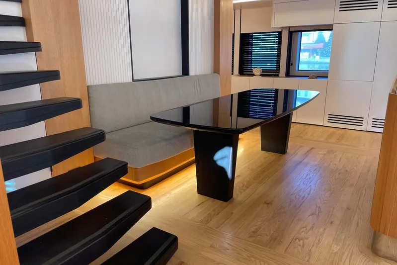  Yacht Photos Pics Modern interior of 2024 Explorer ICE with sleek black table and wooden flooring.