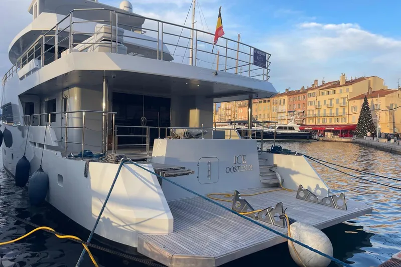  Yacht Photos Pics Luxury 2024 Explorer ICE yacht docked in a scenic harbor with festive decorations.