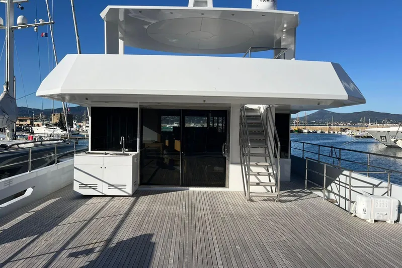  Yacht Photos Pics 2024 Explorer ICE yacht deck with stairs, marina view, and clear blue sky.