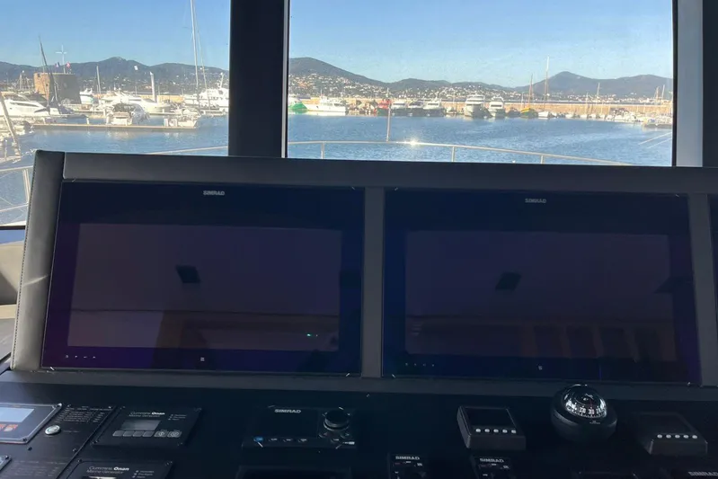  Yacht Photos Pics 2024 Explorer ICE yacht cockpit with dual Simrad displays, overlooking marina and mountains.