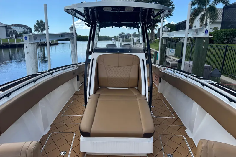  Yacht Photos Pics 2020 Fountain 38 Center Console boat with tan seating, docked by a waterfront.