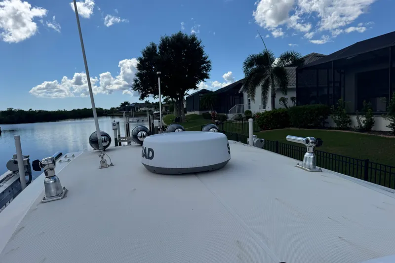  Yacht Photos Pics 2020 Fountain 38 Center Console boat docked by waterfront homes under a blue sky.
