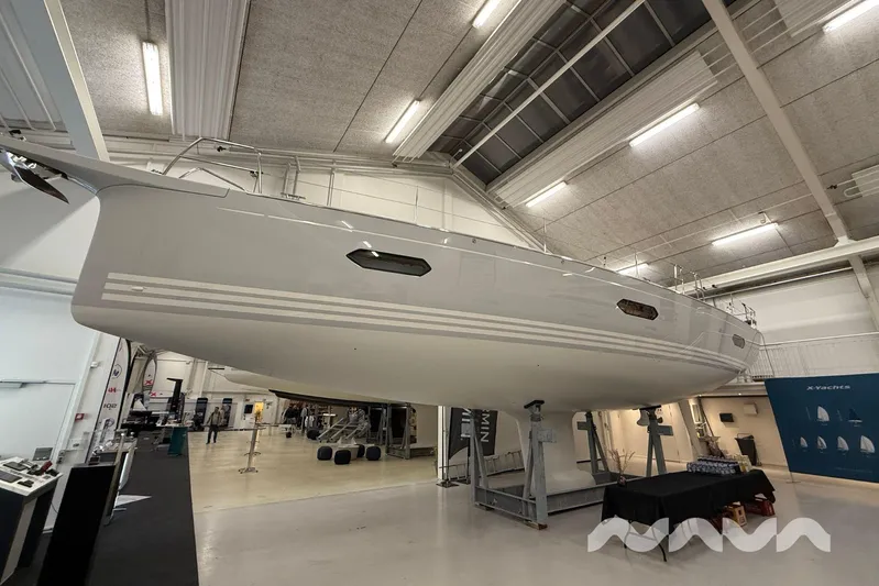  Yacht Photos Pics 2024 X-Yachts Xc 47 sailboat displayed indoors, showcasing sleek design and modern features.