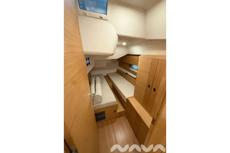  Yacht Photos Pics 2024 X-Yachts Xc 47 cabin interior with wooden furnishings and cozy bedding.
