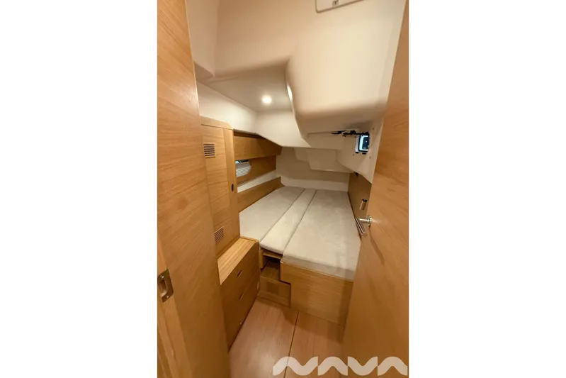  Yacht Photos Pics 2024 X-Yachts Xc 47 cabin interior with wooden finish and cozy bedding.