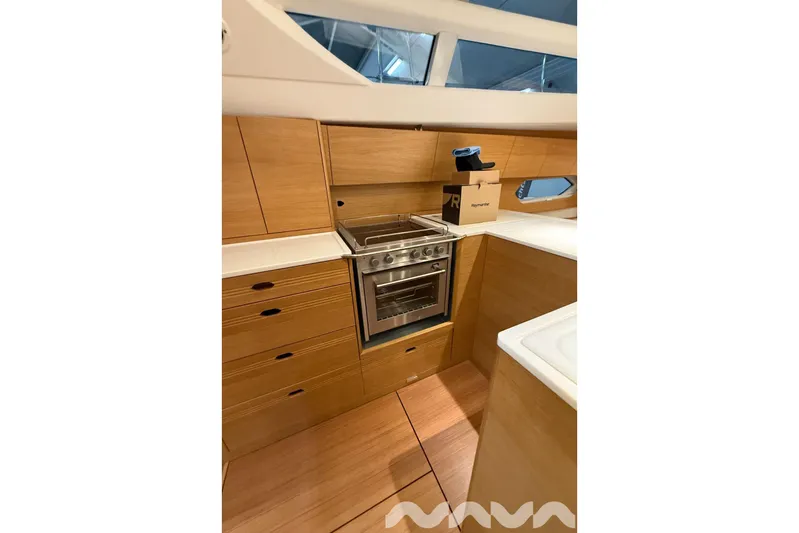  Yacht Photos Pics 2024 X-Yachts Xc 47 yacht kitchen with wooden cabinetry and modern appliances.