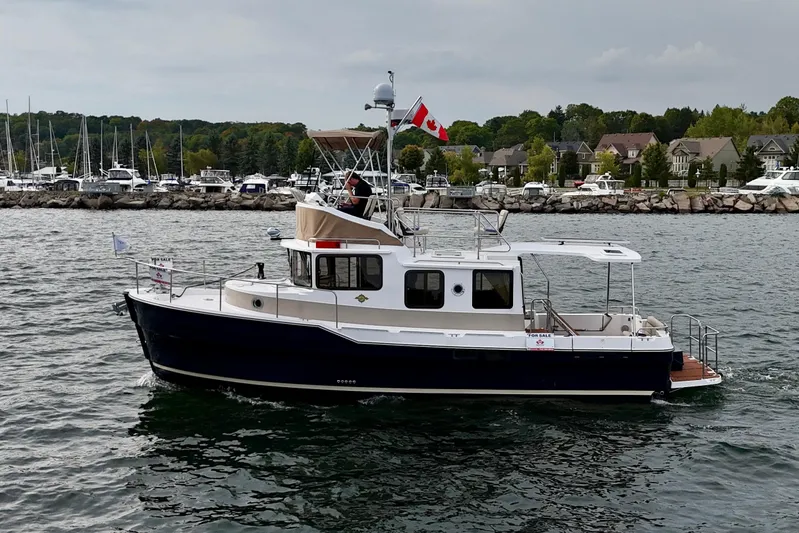  Yacht Photos Pics 2025 Ranger Tugs R-31 CB boat cruising near marina with Canadian flag.