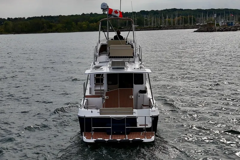  Yacht Photos Pics 2025 Ranger Tugs R-31 CB cruising on a lake with a Canadian flag.