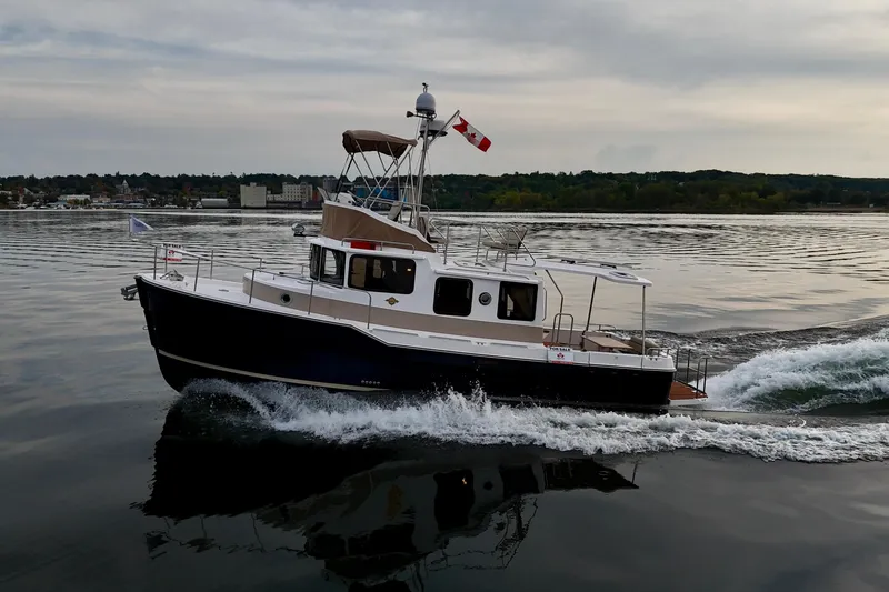  Yacht Photos Pics 2025 Ranger Tugs R-31 CB cruising on calm waters with Canadian flag.