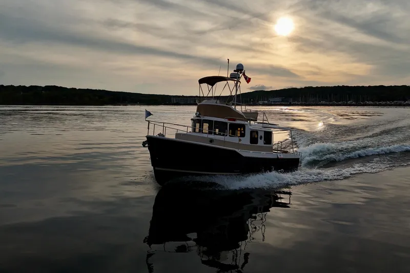  Yacht Photos Pics 2025 Ranger Tugs R-31 CB cruising on calm water at sunset.