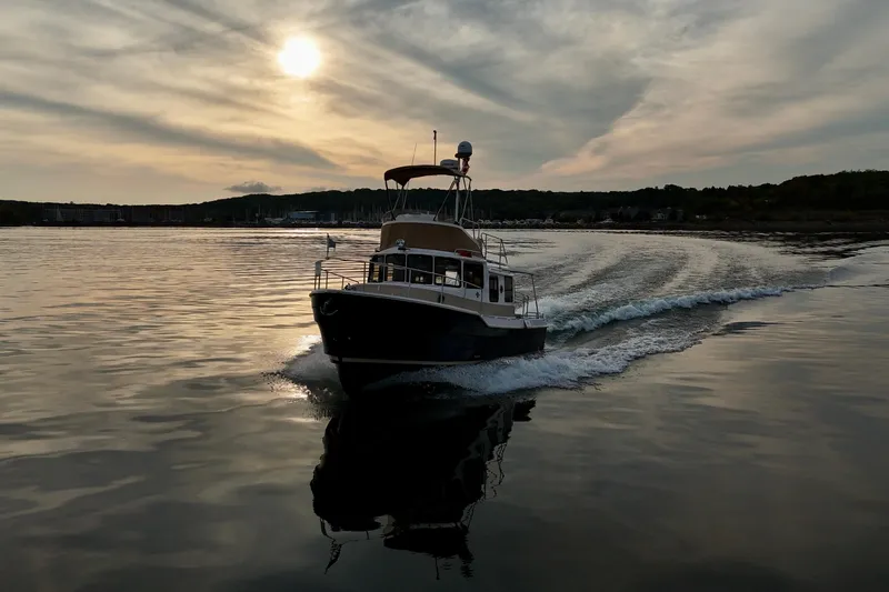  Yacht Photos Pics 2025 Ranger Tugs R-31 CB cruising on calm water at sunset.