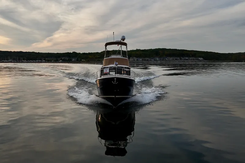  Yacht Photos Pics 2025 Ranger Tugs R-31 CB cruising on calm water at sunset.