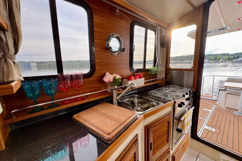  Yacht Photos Pics 2025 Ranger Tugs R-31 CB interior kitchen with wood accents and scenic water view.